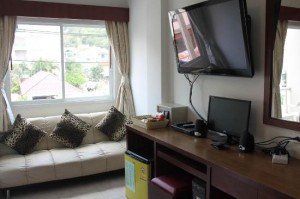 Forest Patong Hotel room with sofa, flat TV and desk